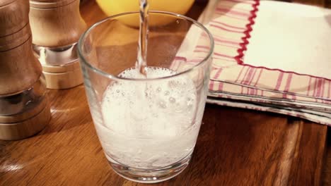 agua mineral vertiendo en un vaso, el desayuno de la mañana, cámara lenta con toma de seguimiento de rotación.