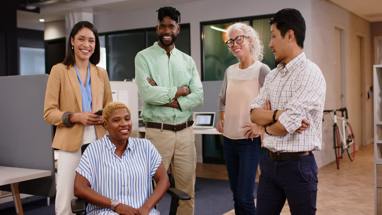 Smiling business team standing and sitting in modern office, collaborating together