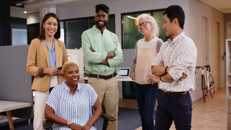 smiling business team standing and sitting in modern office, collaborating together