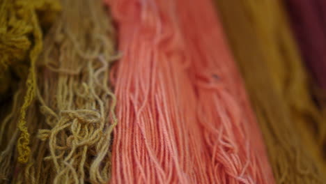 Detailed-closeup-pans-across-colorful-dyed-natural-fibers-used-for-weaving