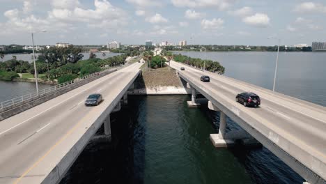 Beautiful-aerial-view-of-traffic-driving-on-bridge-with-city-in-the-background