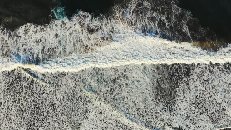 Onde oceaniche che si infrangono viste dall'alto, perfetta simmetria in natura.