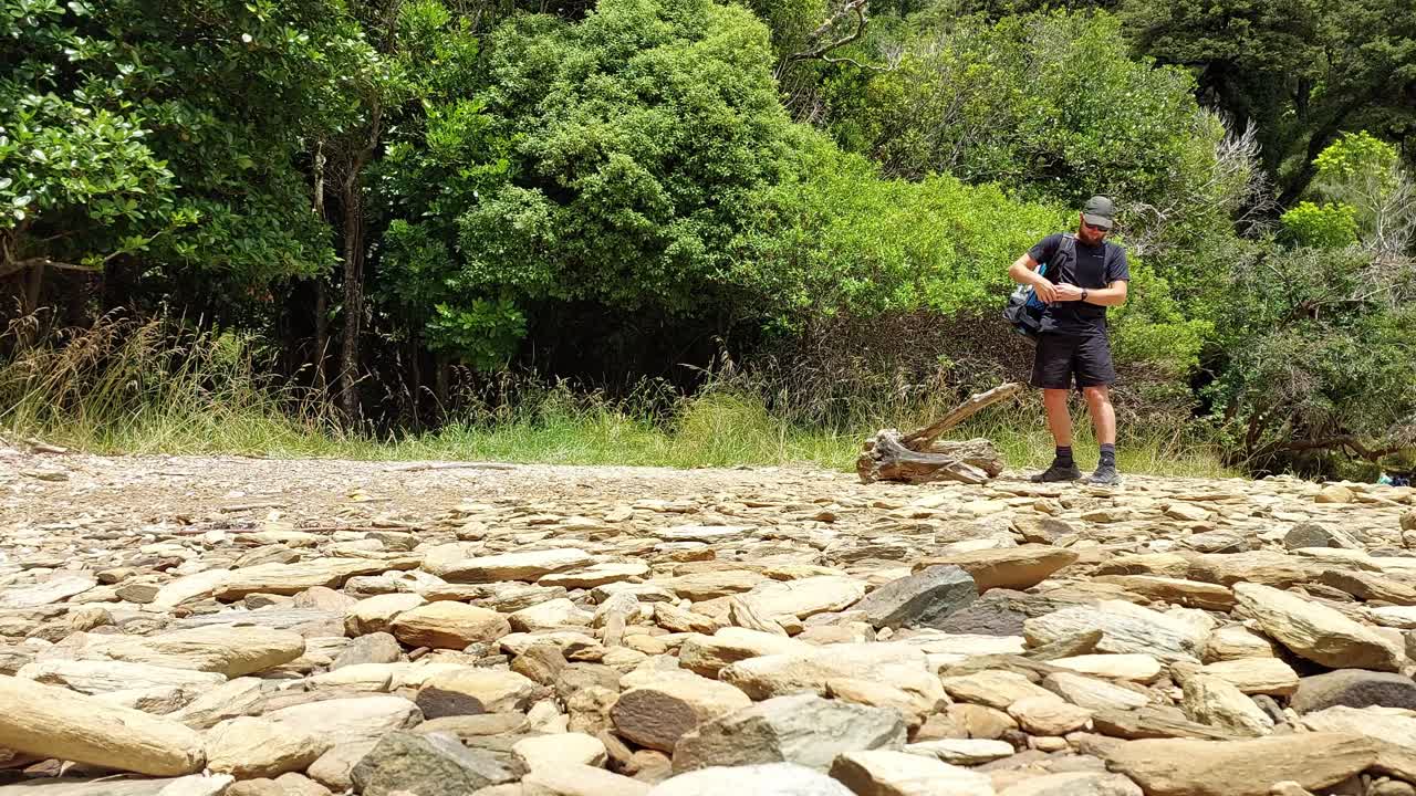 한 남성 등산객이 다가와 숲 속으로 들어가기 전에 배낭을 메고 있다
