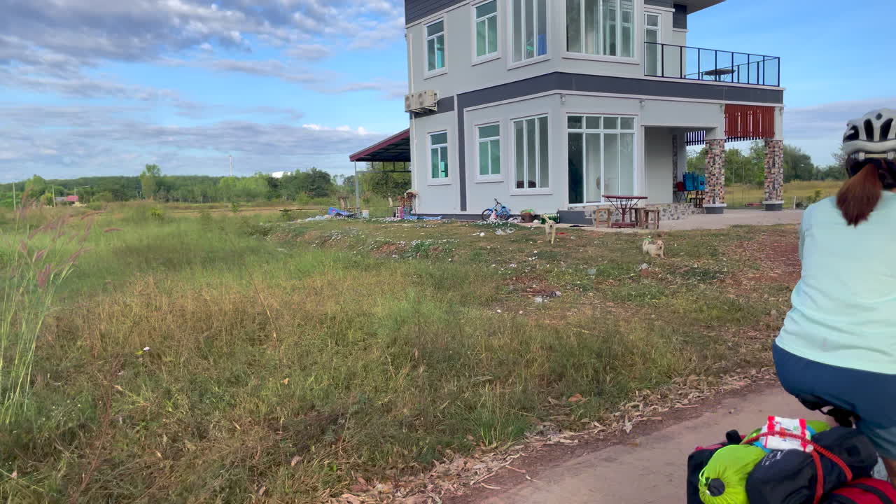 una filmación dinámica de una mujer que viaja en bicicleta con alforjas y comestibles en la parte trasera