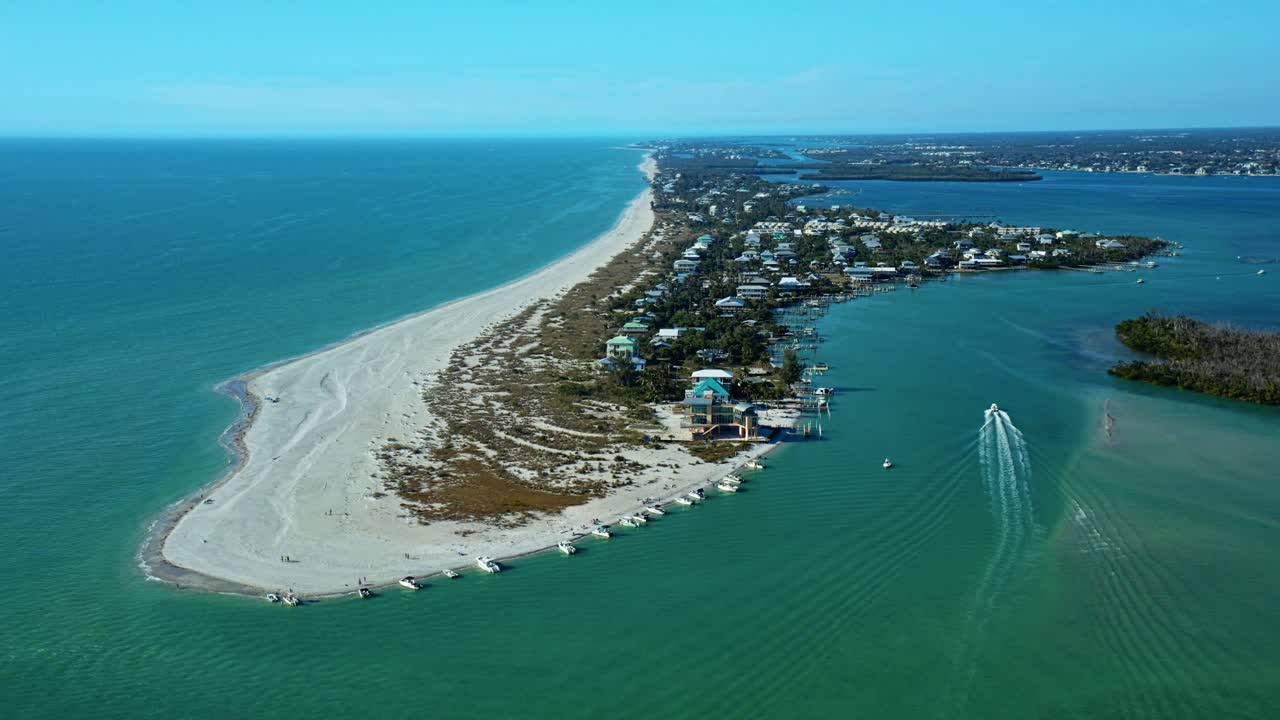 Đảo chắn dọc bờ biển Florida với những bãi biển đầy cát, khu dân cư và nhiều thuyền neo đậu trong làn nước màu ngọc lam nông gần bờ dưới bầu trời xanh quang đãng.