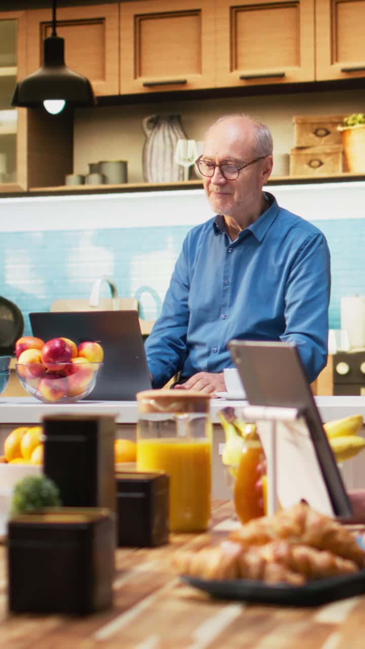 Vertical Video Mature pensioner enjoys happy video conference with family on his laptop