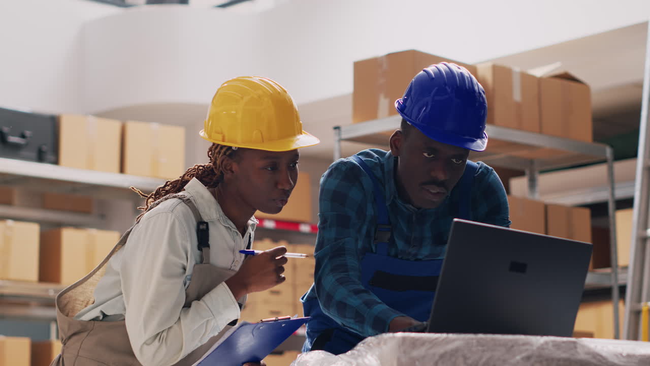 Warehouse workers checking inventory with laptop and clipboard