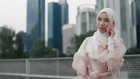 woman in hijab talking on phone in city