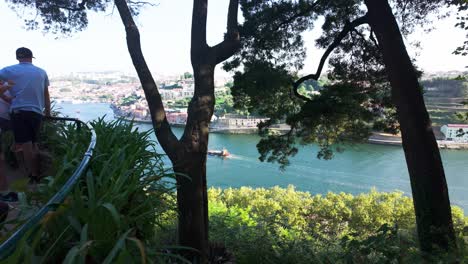 people enjoying a sunny walk through a lush park with views of the douro river in porto