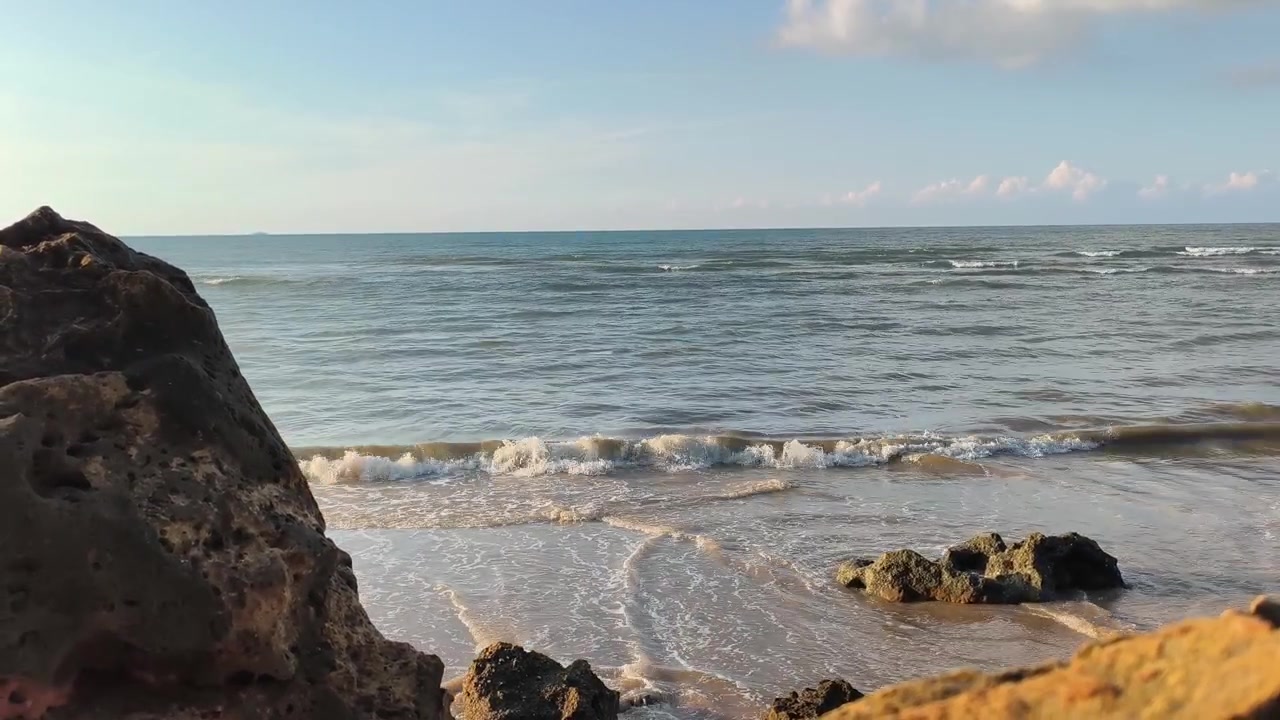 Ondas Suaves do Oceano Quebrando em uma Praia Tropical Rochosa