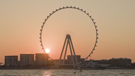 inigualable puesta de sol sobre la rueda de la ferris más grande en el puerto deportivo de dubái.