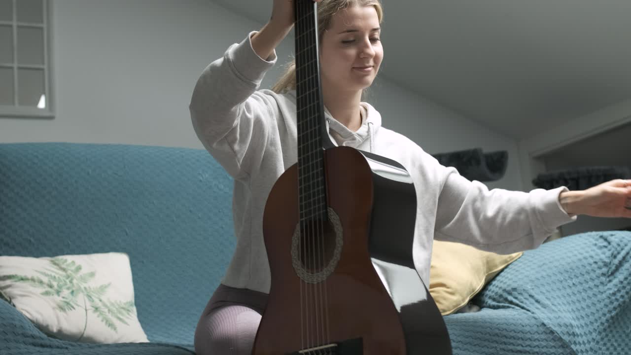 Woman taking acoustic guitar from case and playing