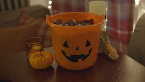 close up pan of a halloween pail filled with candy