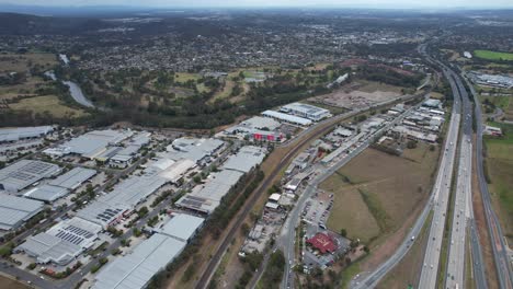 tráfico en la autopista del pacífico cerca de edificios industriales en yatala, queensland, australia
