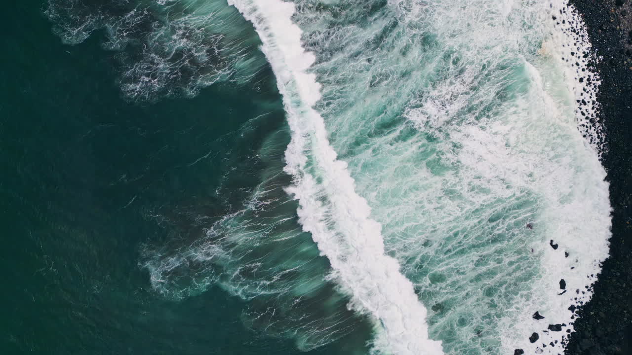 Ocean foam splashing beach rolling drone view. Stormy waves washing black coast