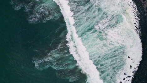 ocean foam splashing beach rolling drone view. stormy waves washing black coast