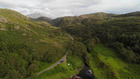 Green-rural-area-with-people-camping-next-to-a-lake