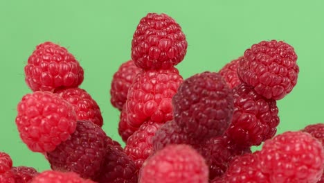 Raspberry berries on green background. Side view. Extrem close-up. Loop motion. Rotation 360.