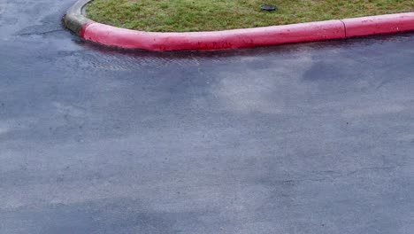 Flowing-rain-on-parking-lot-with-red-curb