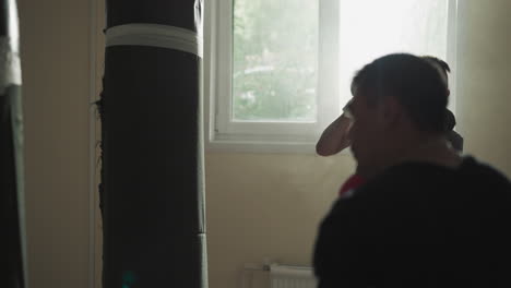 kick-boxers beat punching bags together in sports club. professional sportsmen kick and punch hanging equipment in fighting team gym slow motion