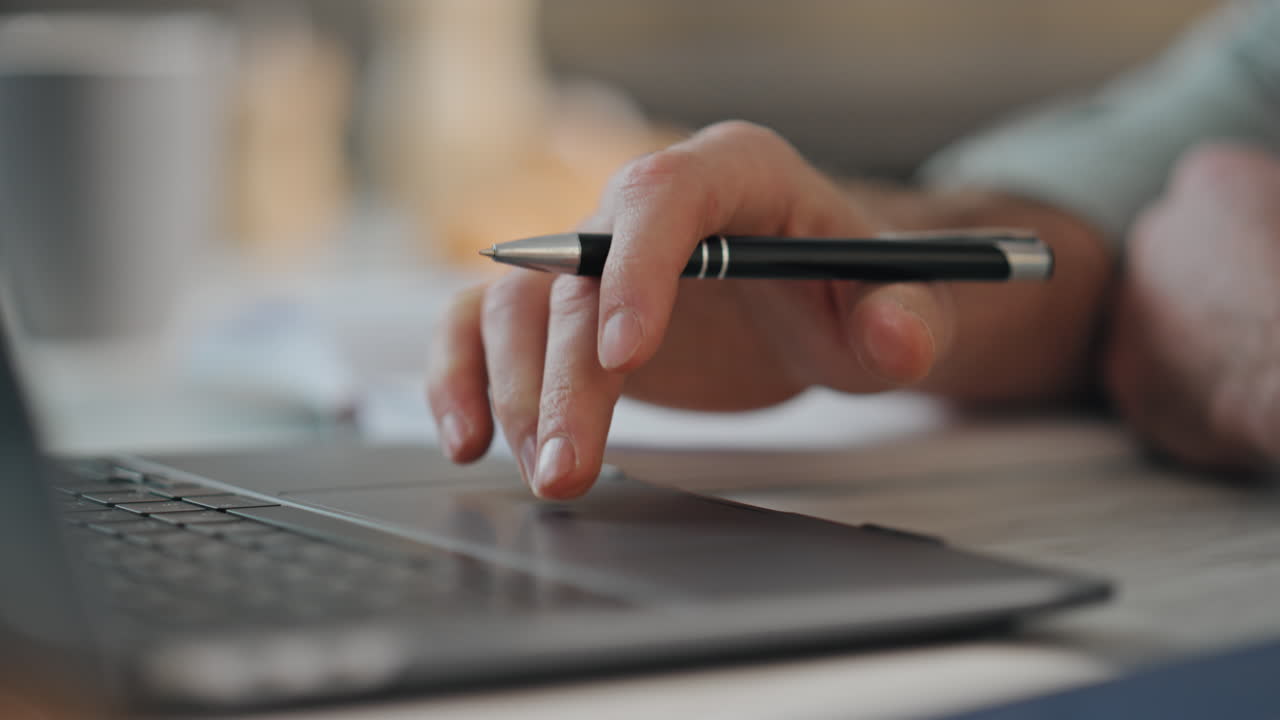 책상에서 노트북을 쓰고 있는 남자 손. 노트북으로 온라인에서 일하는 남자.