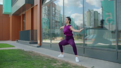 woman practicing yoga outdoors by a building