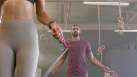 Sección-Media-De-Diversas-Mujeres-Y-Hombres-Entrenando-En-El-Gimnasio-Saltando-La-Cuerda,-En-Cámara-Lenta