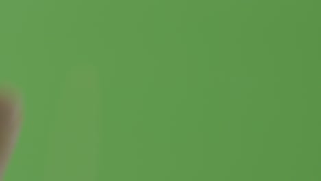 primer plano de un dedo tocando un fondo de pantalla verde