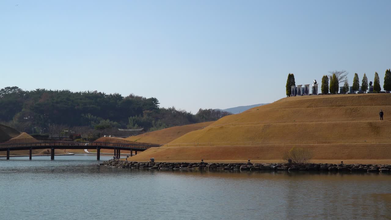 Man-made Lake Garden with Bonghwa Hill and Bridge of Dreams in Suncheon Bay National Park over clear sky - copy space landscape