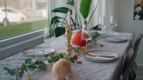 platos, copas de vino y adornos en la mesa de la cena de acción de gracias.
