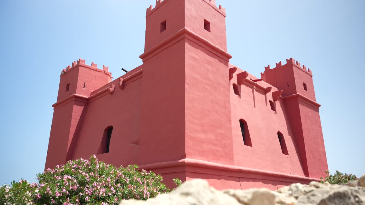 Looking up at popular Red Tower in Malta. Colourful fairytale castle in Mediterranean