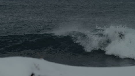 El-Surfista-Se-Desliza-A-Lo-Largo-De-La-Cima-De-Una-Fuerte-Ola-ártica-Rápidamente-Recortando-Y-Rociando,-Siguiendo-El-Seguimiento