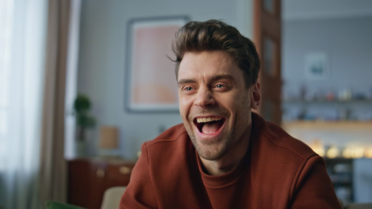 Excited guy watching football tv game in living room close up. Man looking show