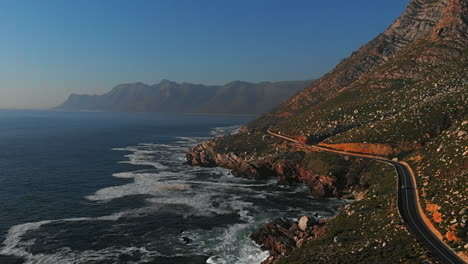 broll of aerial drone flying over clarens drive gordons bay with rocks, boulders, sea, ocean cliffs and crashing white wash waves