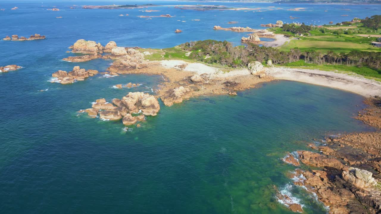 Côte de Granit Rose in Brittany, famous pink granite rocks, turquoise sea, secluded sandy beach, France. Aerial backward ascending, copy space