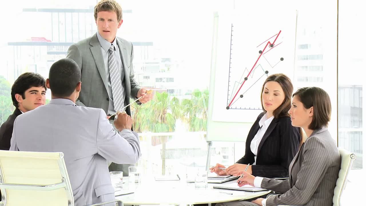 사업가 가 팀 에게 판매 수치 를 보고 하고 있다