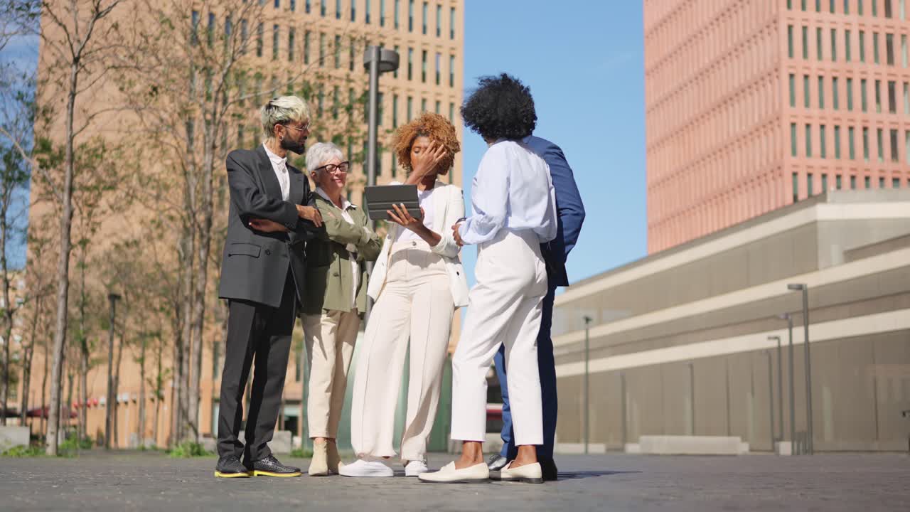 Multi-ethnic business people using digital tablet outdoors