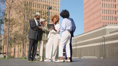 multi-ethnic business people using digital tablet outdoors