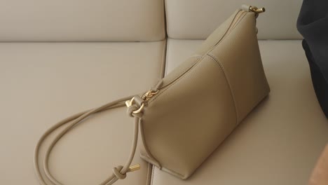 elegant beige leather handbag on a sofa