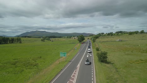 Fast-low-sweep-across-busy-countryside-highway-A66-on-cloudy-summer-day