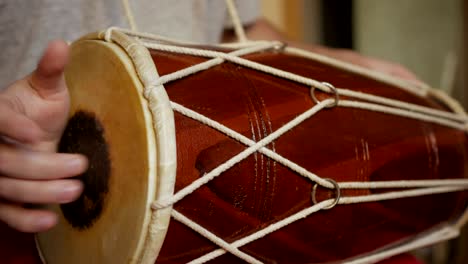 close up of hands of a man playing a drum.