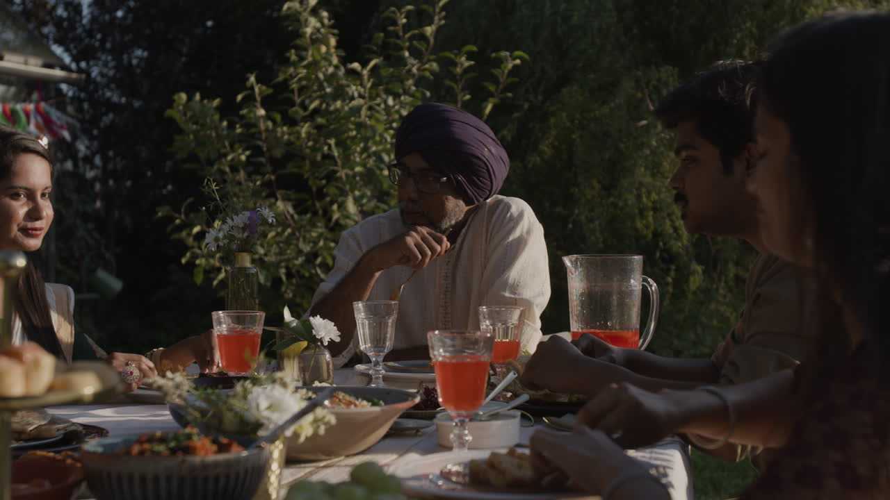 Multi-Generational Family Enjoying an Outdoor Meal in a Sunny Garden