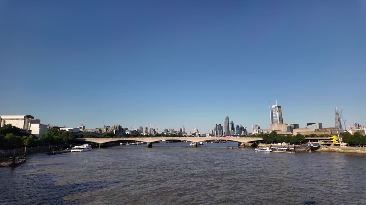 Waterloo Bridge spanning River Thames with city skyline in sunny weather. Establishing Shot