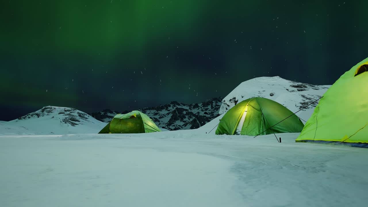 Green Tents Under Aurora Borealis in Snowy Mountains