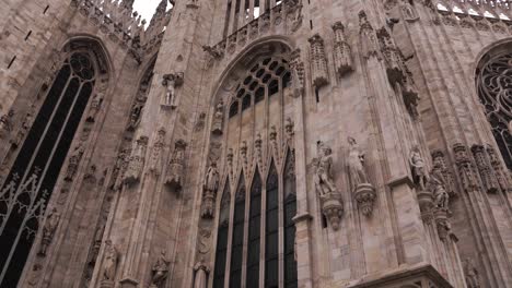 a shot of the exquisite exterior of milan's duomo showcases the iconic blend of baroque architecture, adorned with statues and rich medieval history in the touristic city center