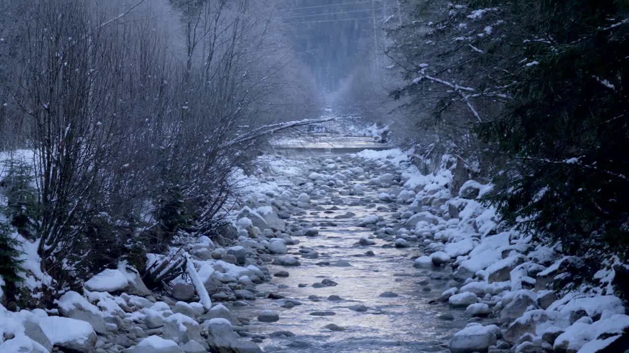 안개 가 가득 한 산 의 하천 이 눈 인 풍경 을 가로질러 흐른다