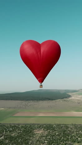 globo de aire caliente en forma de corazón sobre un paisaje pintoresco