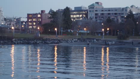 Beach,-lights-reflected-on-water--and-buildings