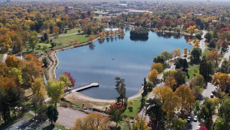 a 4k drone shot over washington park and tennis courts, mount vernon garden, and grasmere lake, in denver, colorado, on a peaceful day, during the colorful fall season