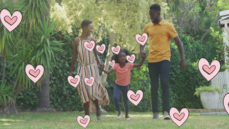 animation of hearts over happy african american family in garden